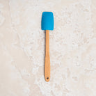 Mini Silicone Spoon Spatula in Blue on a beige background at Addison West