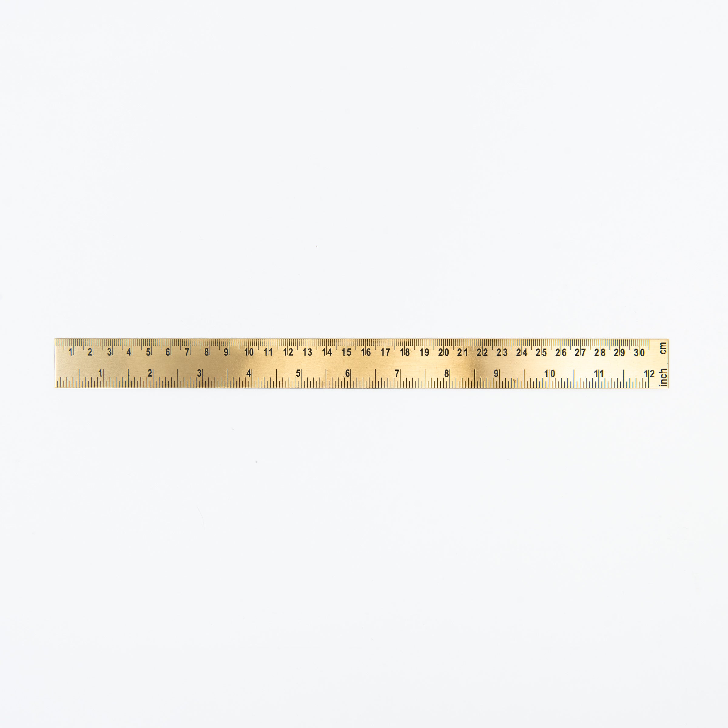 Brass ruler on a white background at Addison West