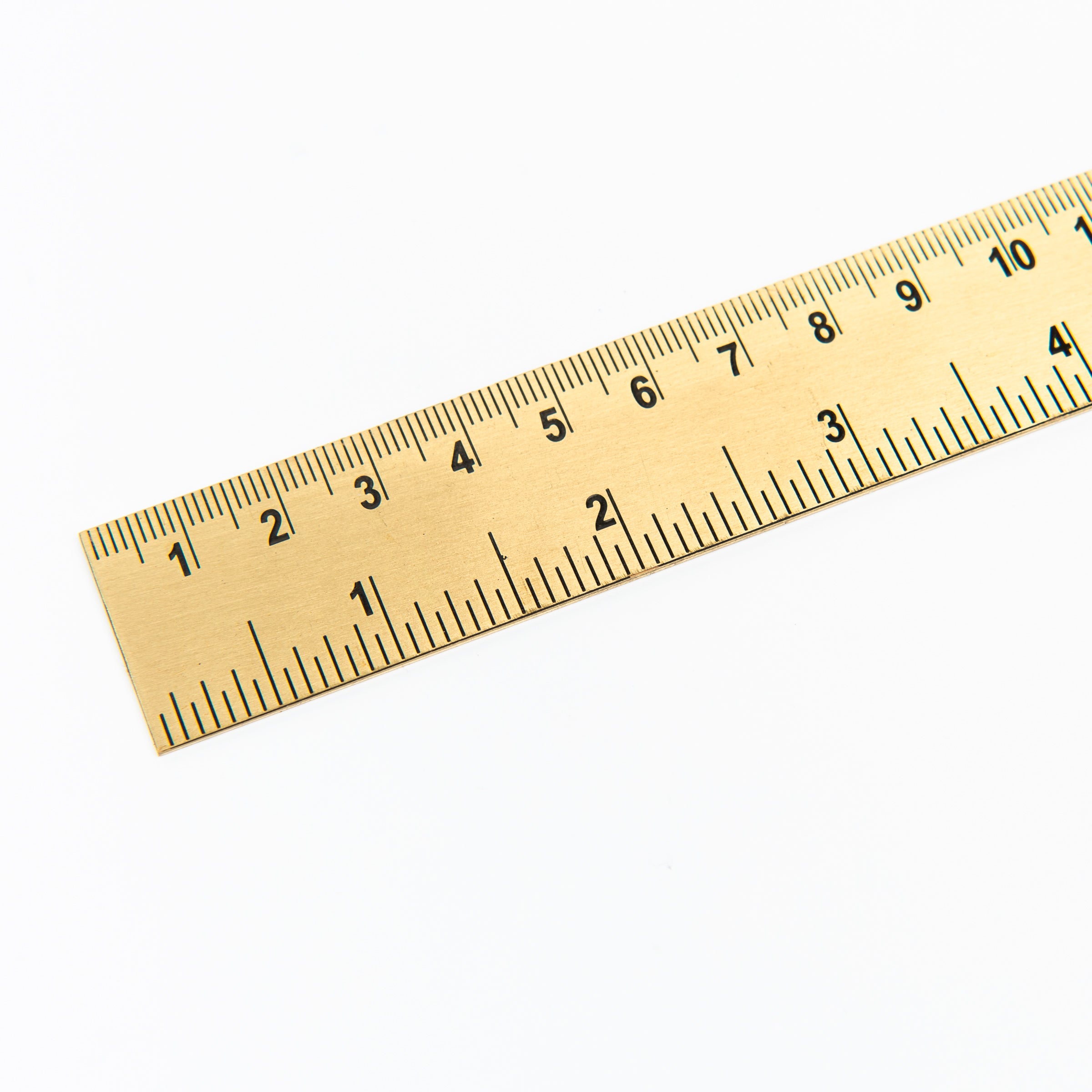 Brass ruler on a white background at Addison West