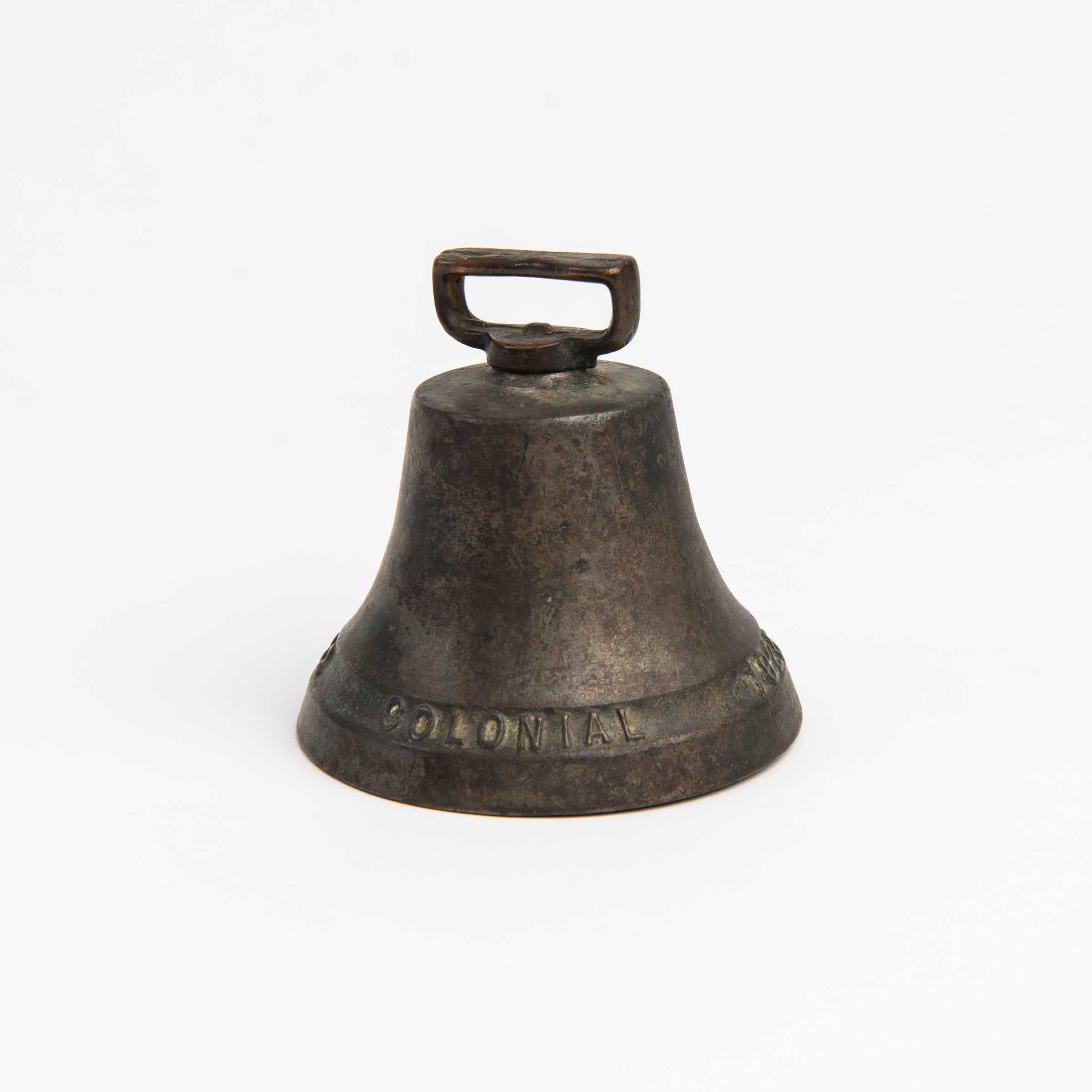 Vintage Bronze Colonial Bell on a white background at Addison West