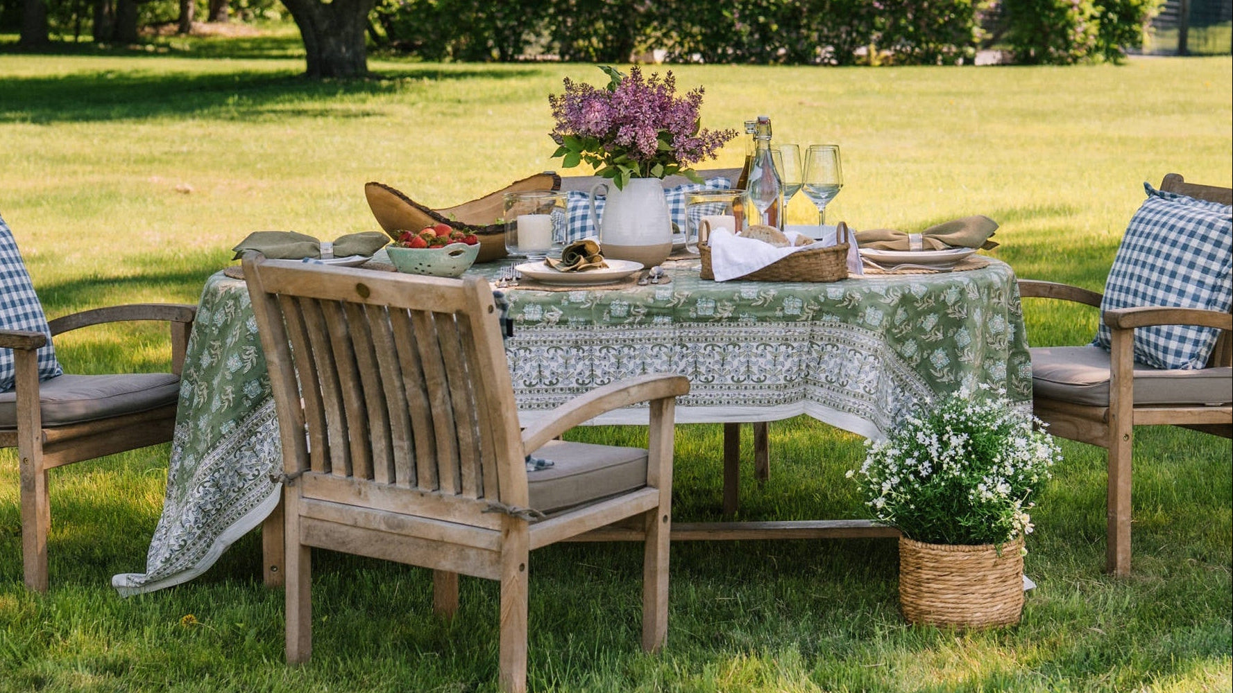 Outdoor table with hand block printed tablecloth, handmade farmhouse pottery ceramic pitcher and other hand made tabletop pieces at Addison West