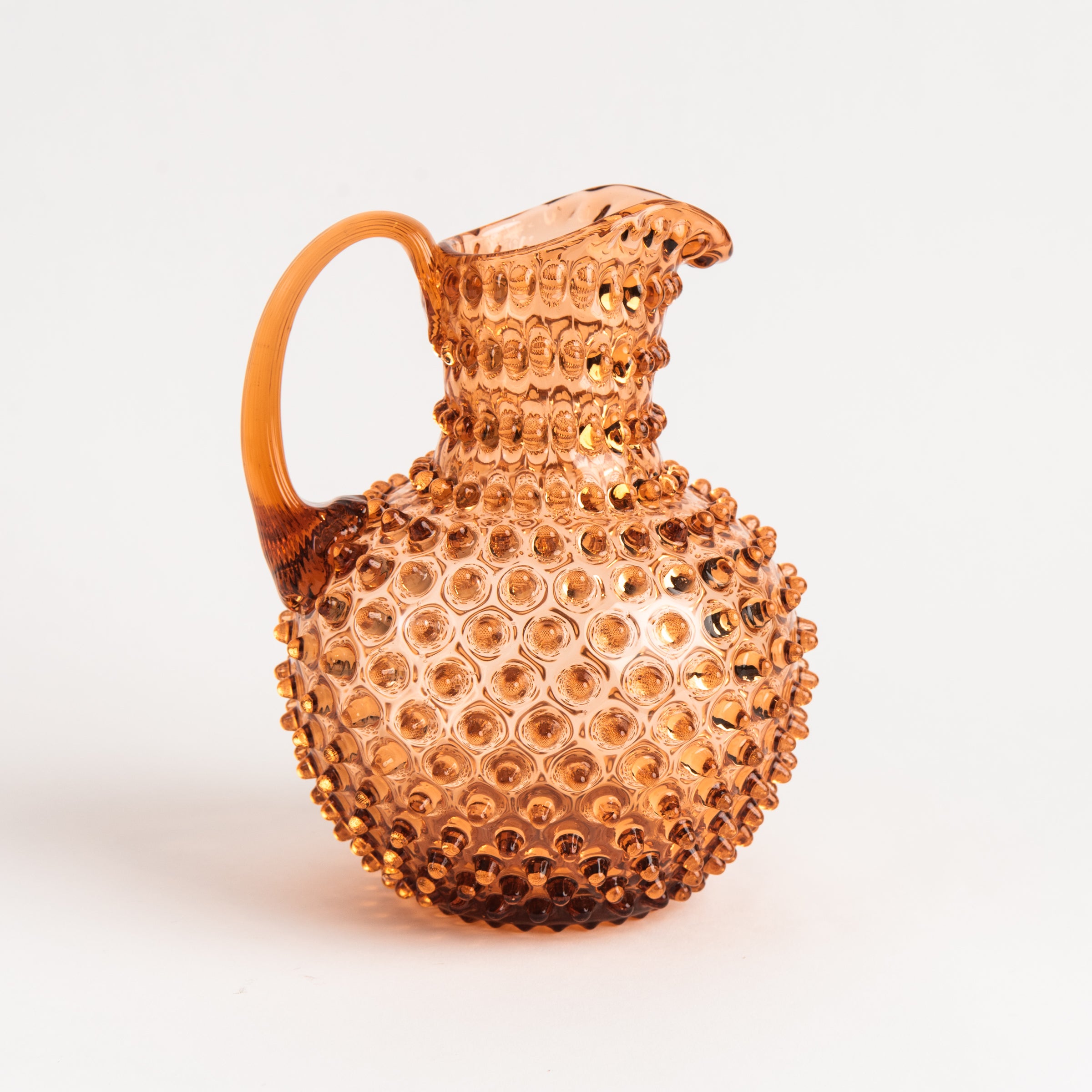 Hobnail Glass Pitcher in Honey Gold on a white background at Addison West