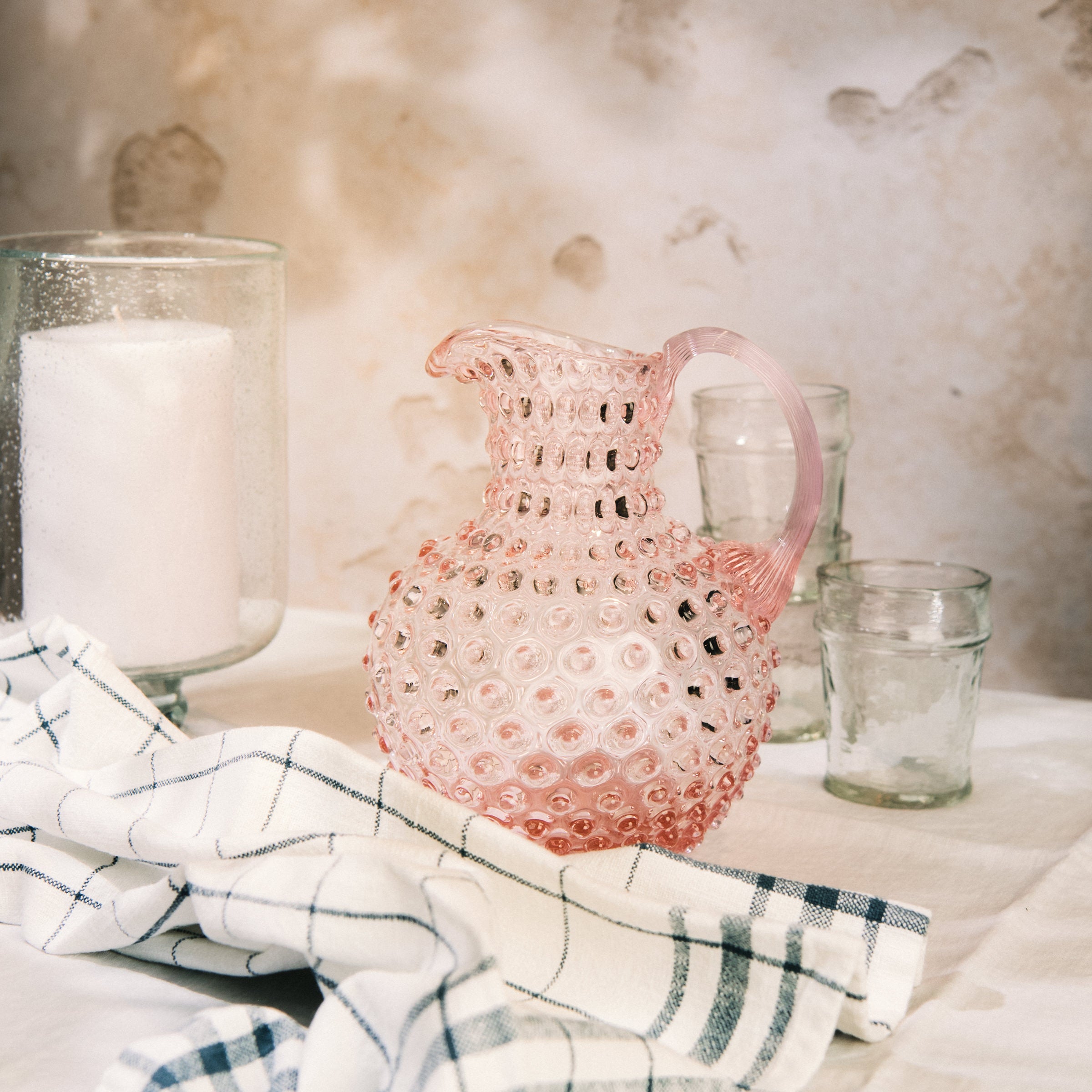 Hobnail Glass Pitcher in Petal Pink on a table at Addison West