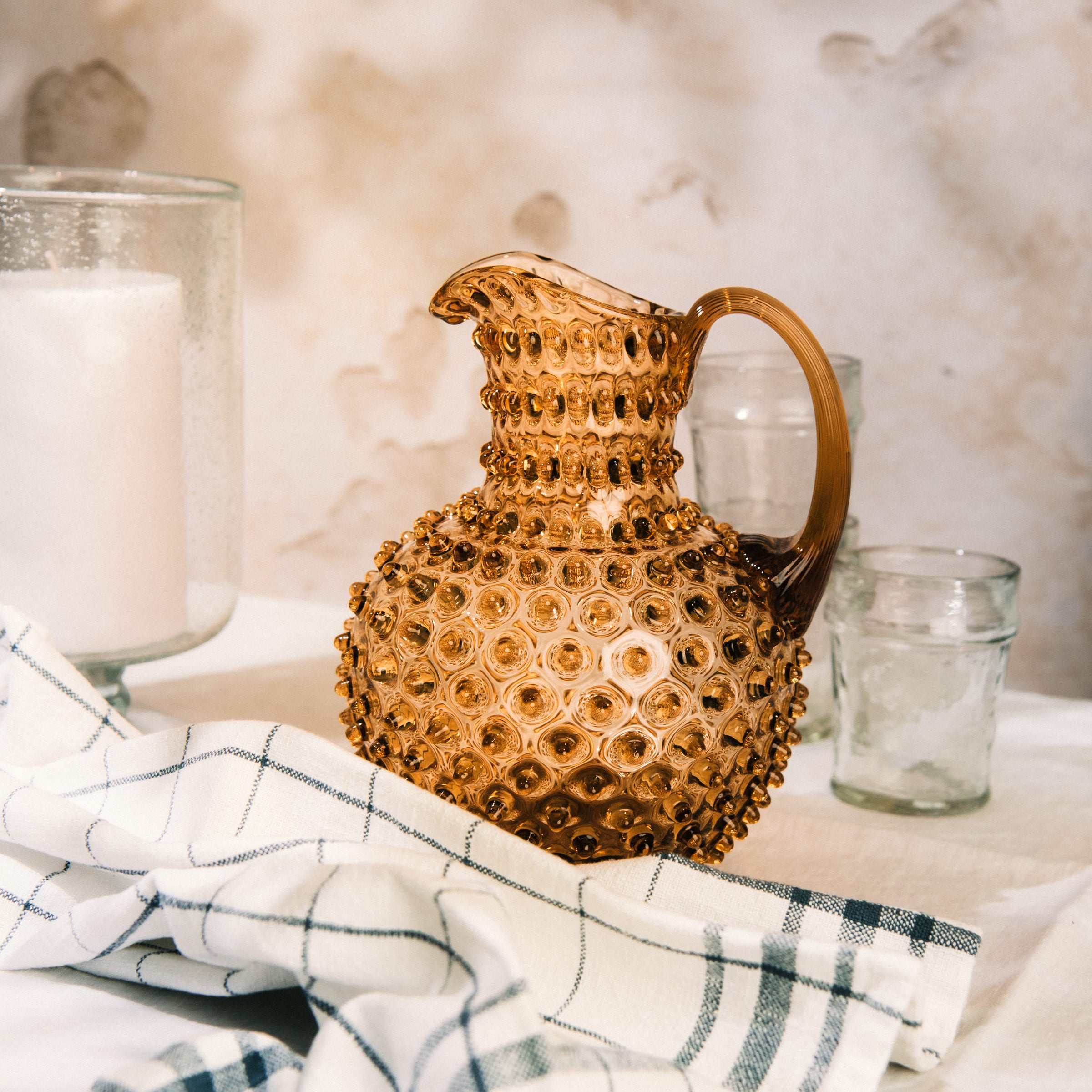 Hobnail Glass Pitcher in Honey Gold on a table at Addison West