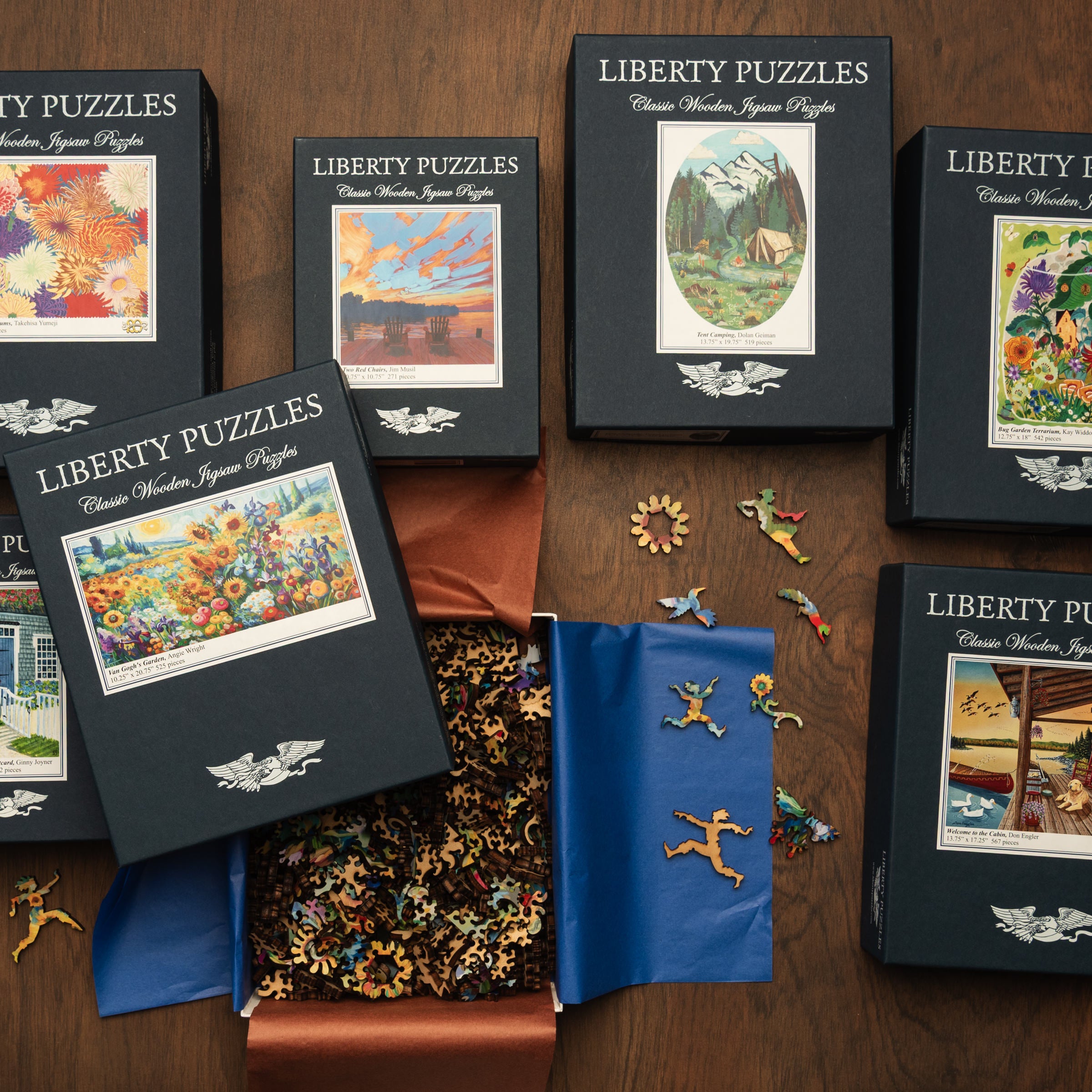 Collection of Liberty Puzzles handmade wooden jigsaw puzzles on a wood table at Addison West