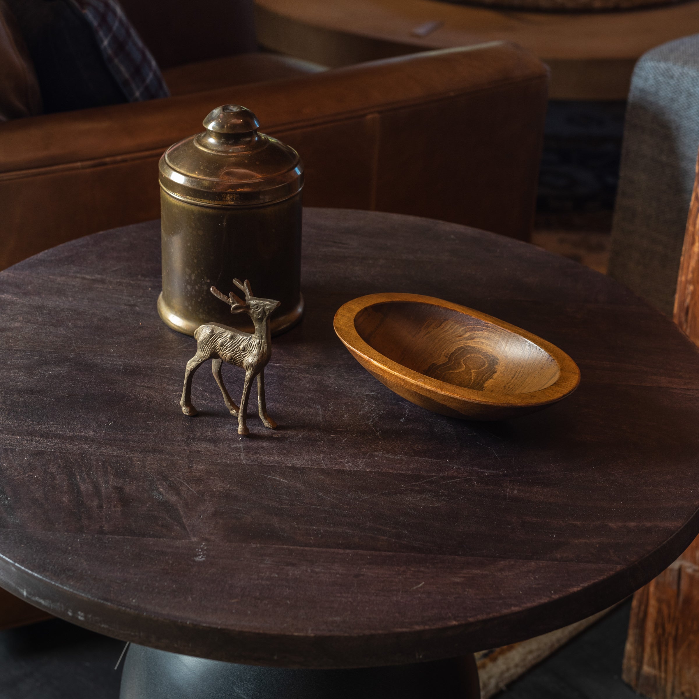 Vintage Brass Tobacco Tin vintage brass reindeer and vintage wood bowl on a dark wood table at Addison West