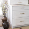 White kitchen with glass cabinet and open shelves with two brown urns on the floor