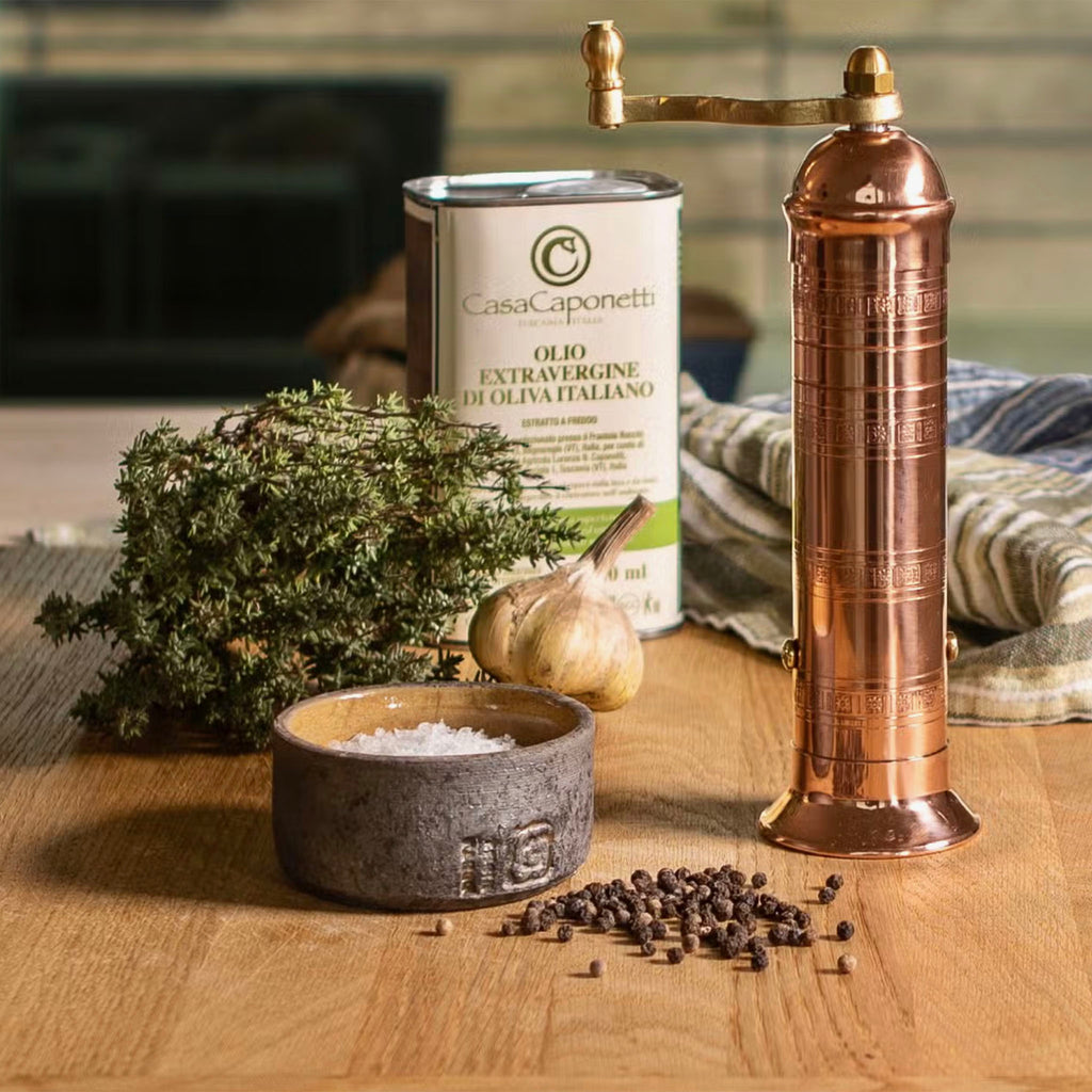 Alexander 8" Copper Pepper Mill on a wood surface with herbs and olive oil 