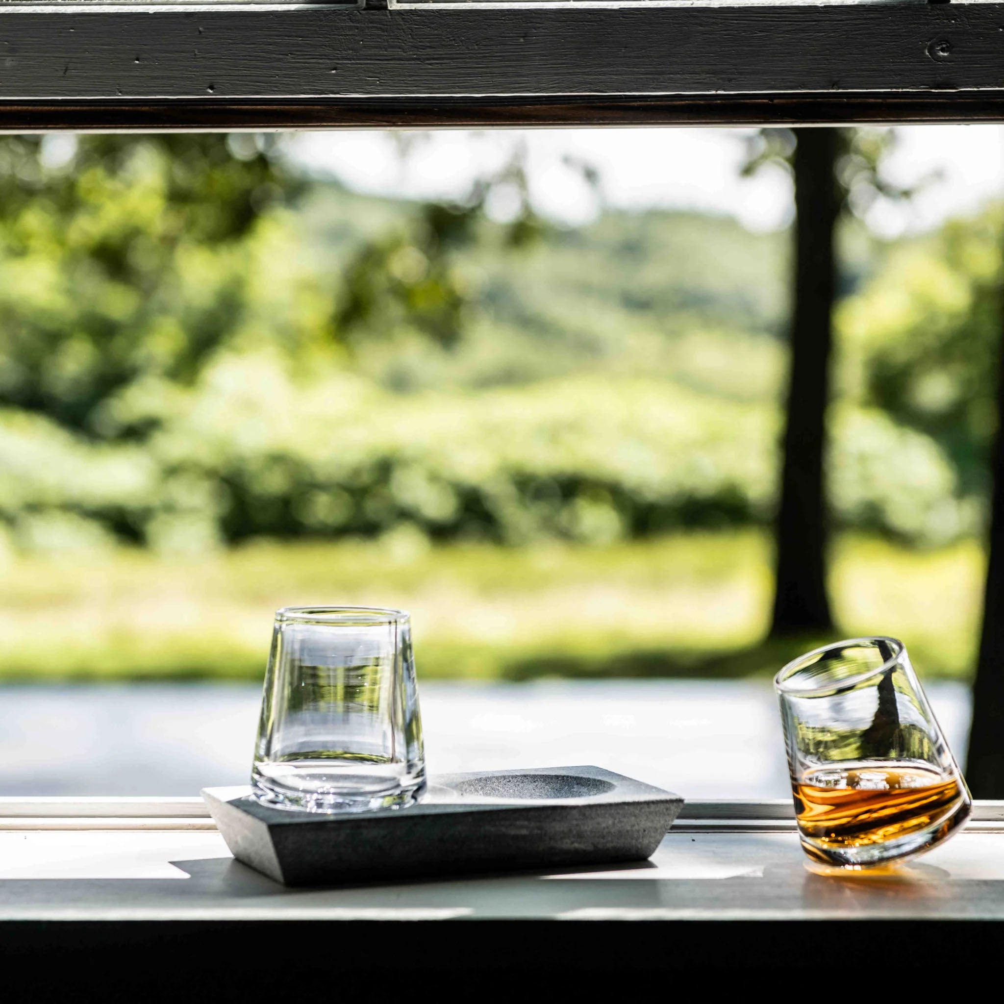 Simon Pearce Alpine Whiskeys, Set of 2 on a windowsill at Addison West