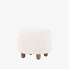 Four hands brand Aniston ottoman in natural shearling style upholstery on a white background