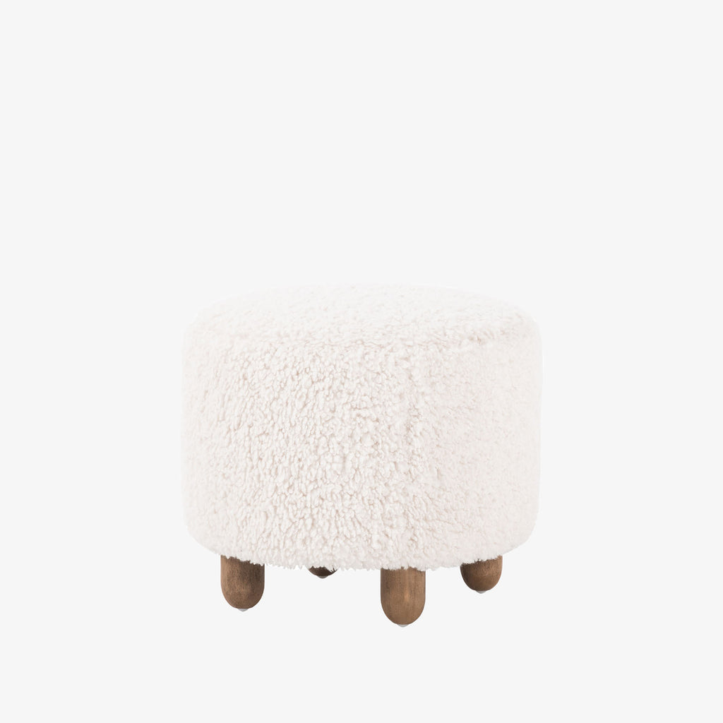 Four hands brand Aniston ottoman in natural shearling style upholstery on a white background