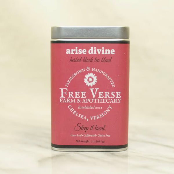 Metal Tin with pink label of Free Verse apothecary arise divine Loose Leaf Herbal Tea Blend on a beige background