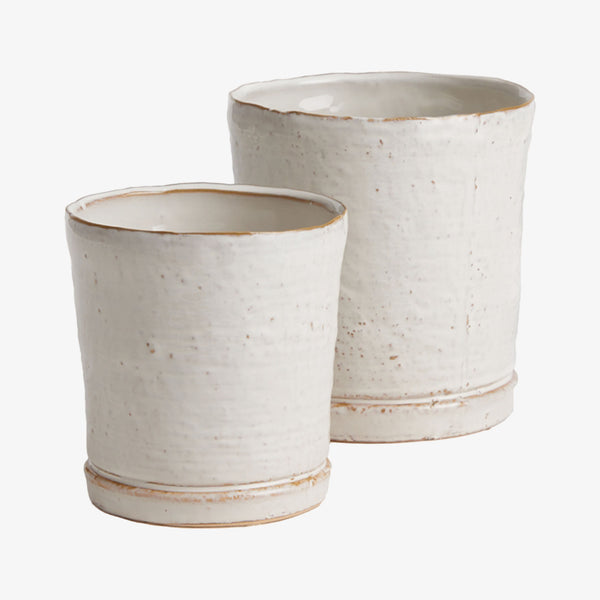 Set of two Asher pots by Napa home with cream finish and integrated saucer on a white background