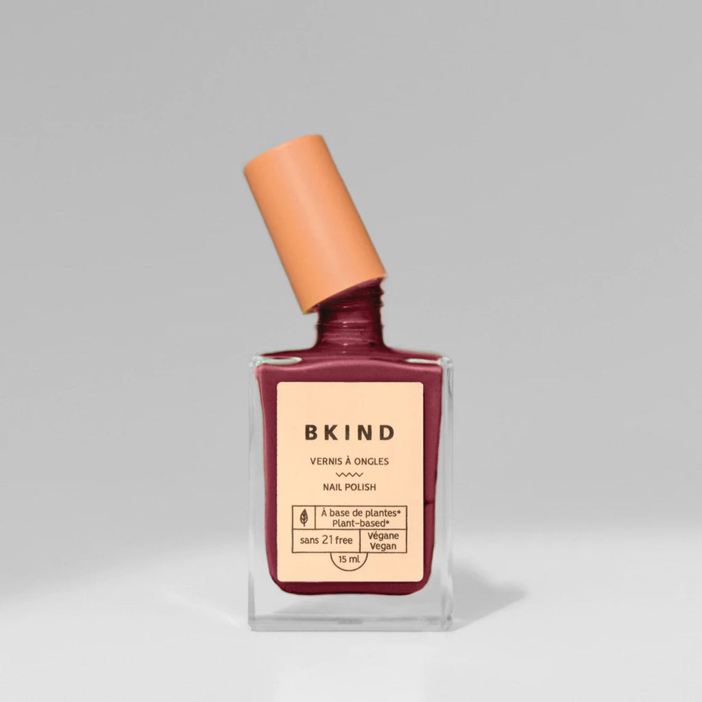 BKIND Nail Polish bottle in Petite Bourgogne burgundy red on a greay background