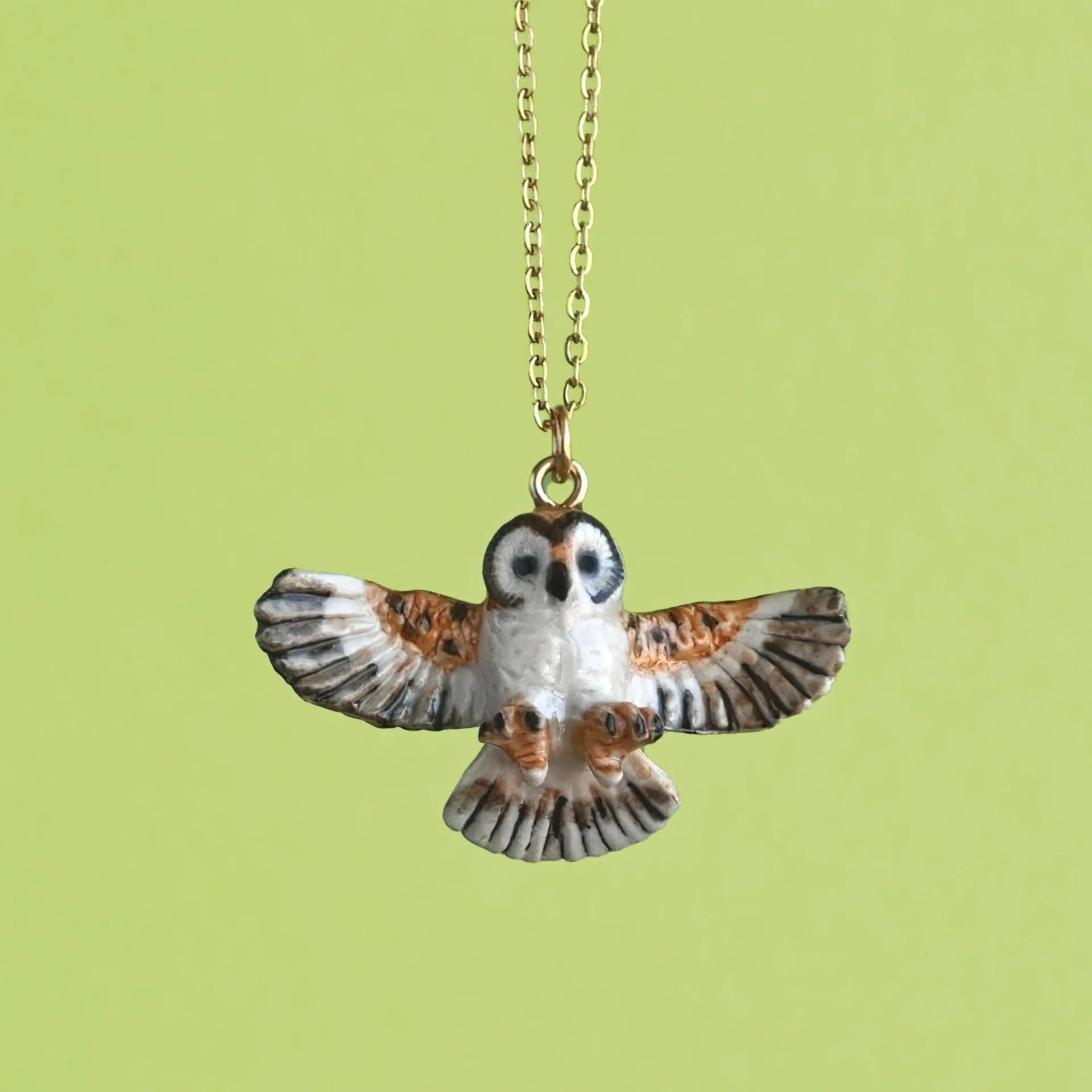 Barn Owl Necklace on a green background at Addison West