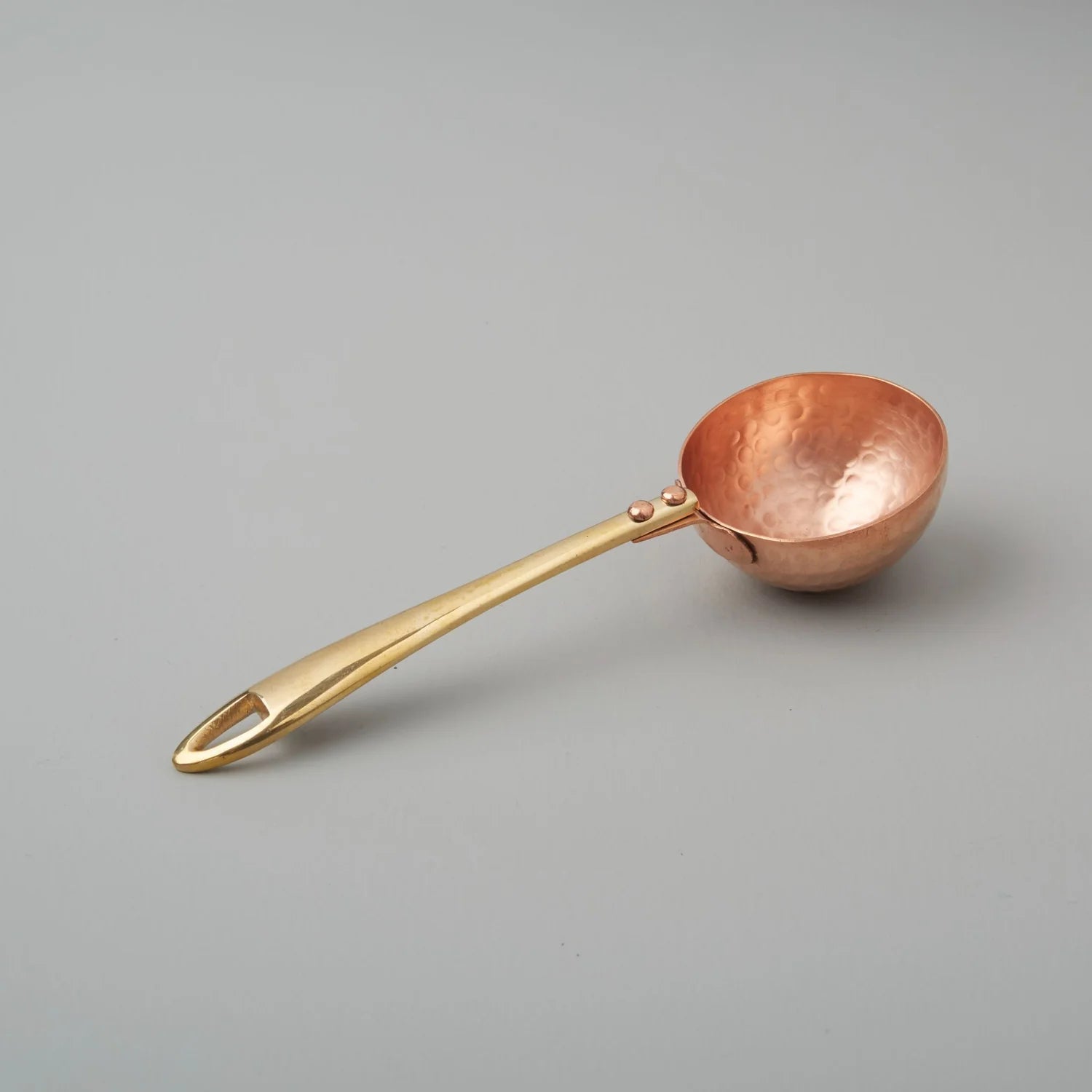 Copper scoop on a gray background