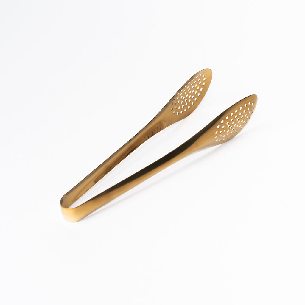 Brass toned slotted tongs on a white background