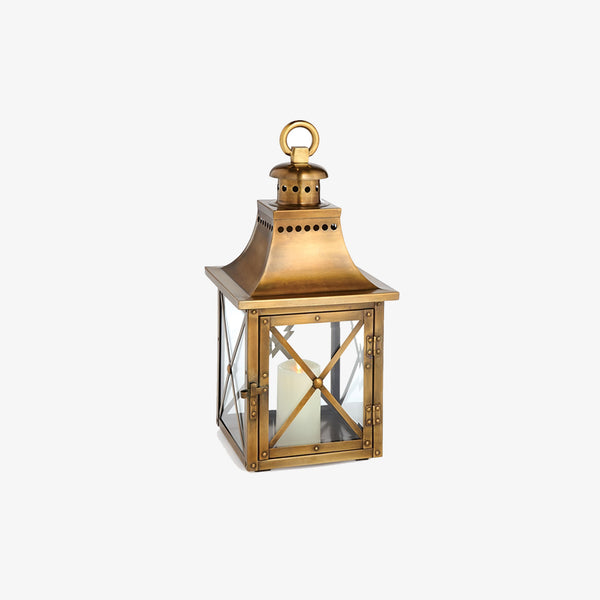 Brass lantern with crisscross glass and arched top on a white background
