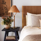 Delphine Table Lamp on a black nightstand next to a bed