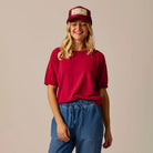 Female model shown wearing the Carve Josie Sweater Tee in Crimson on plain background.