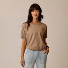 Female model shown wearing Carve Josie Sweater Tee in Dark Barley on plain background.