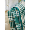 Chappy Wrap Autumn Plaid Evergreen Blanket held by a woman wearing beige pants and a creme sweater