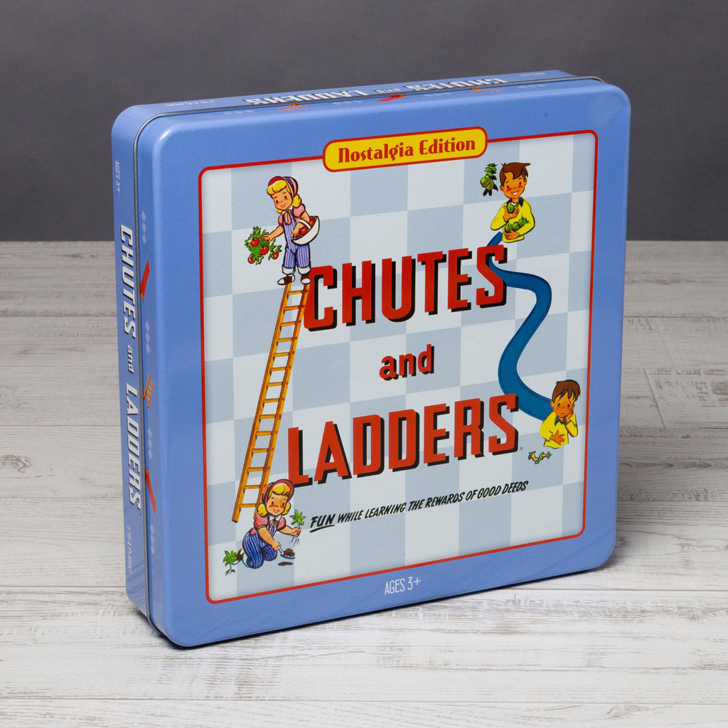 Chutes and ladders game in nostalgia blue tin on a white wood surface