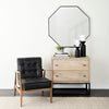 Living space with mirror, black leather chair and Cabinet with two drawers in white washed wood and black metal base on a white background