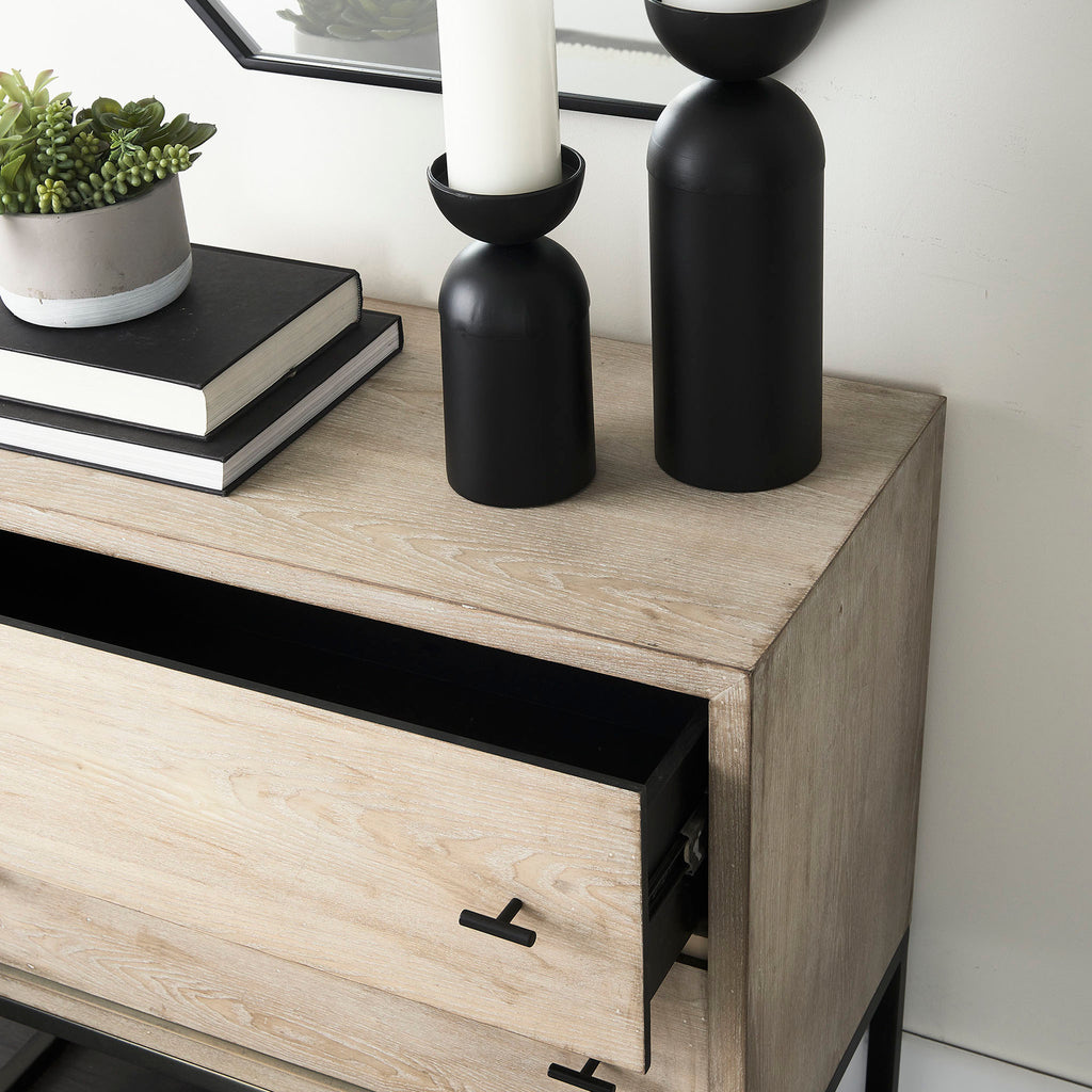 Close up of Cabinet with two drawers in white washed wood and black metal base against a white wall