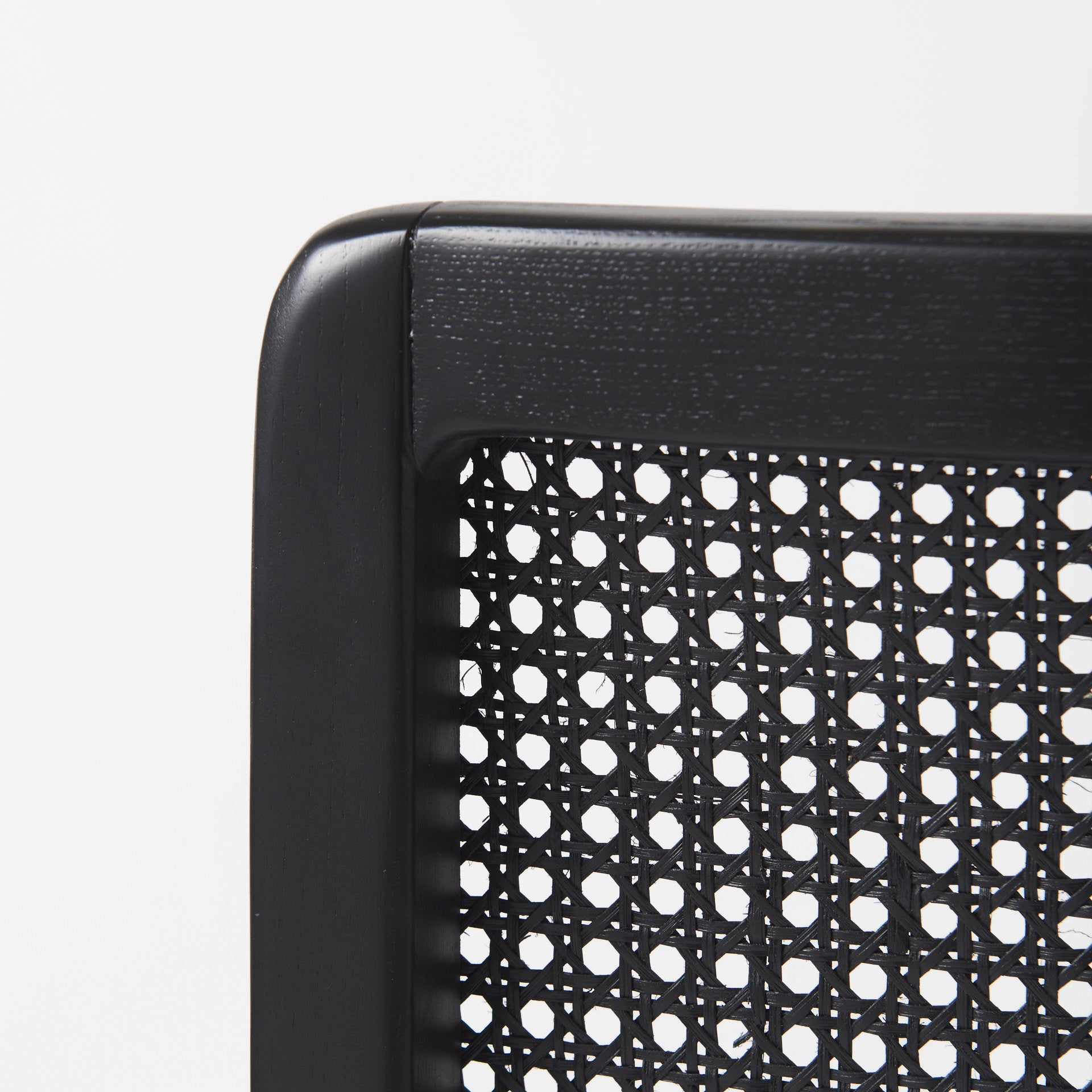 Close up of Clara Black Wood W/ Cream Fabric Seat and Cane Back Armless Dining Chair on a white background