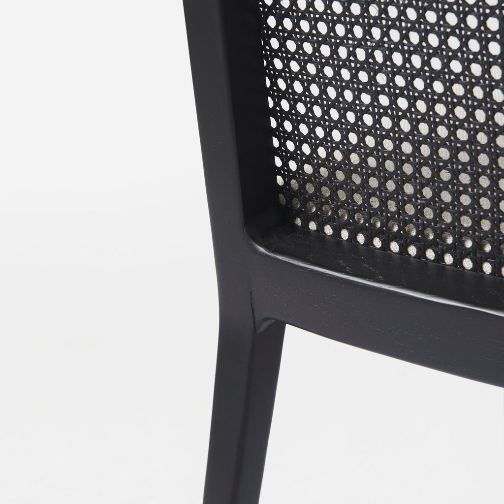 Close up of Clara Black Wood W/ Cream Fabric Seat and Cane Back Armless Dining Chair on a white background