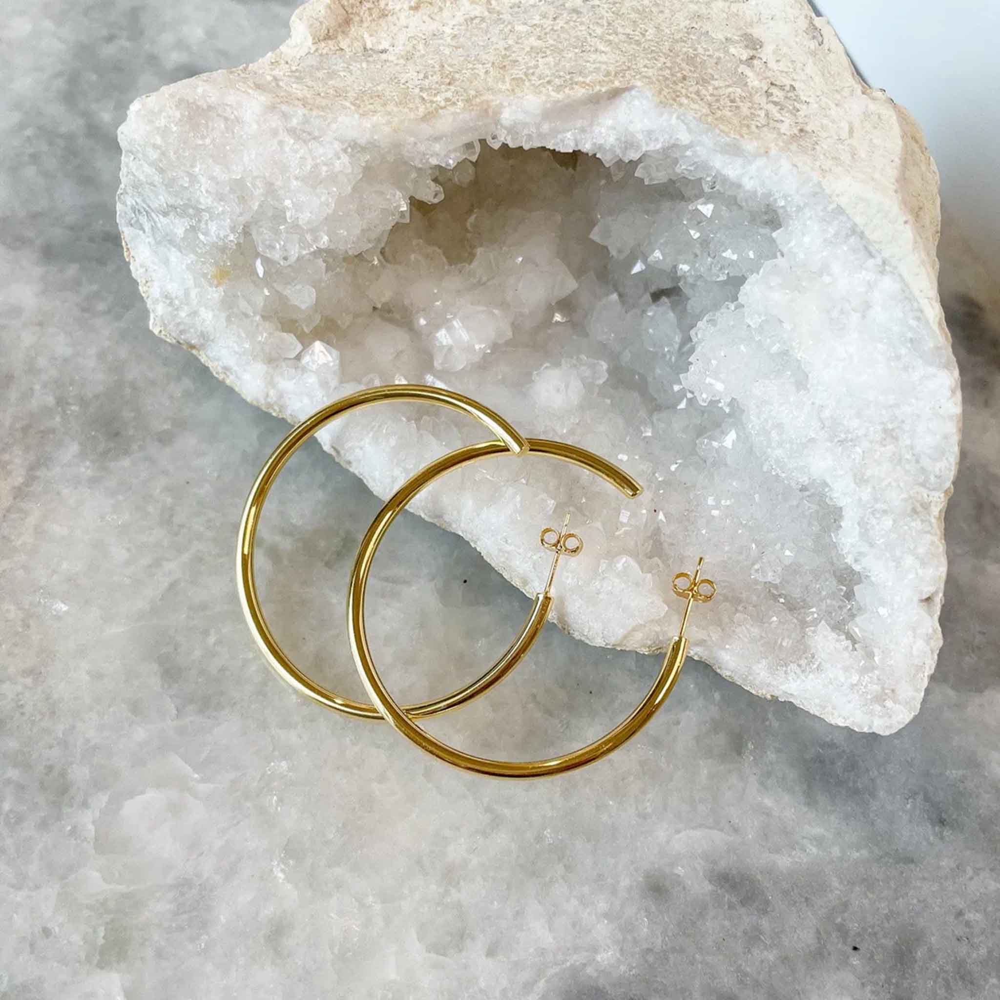 Elli Parr Classic Gold Hoops on a marble background at Addison West