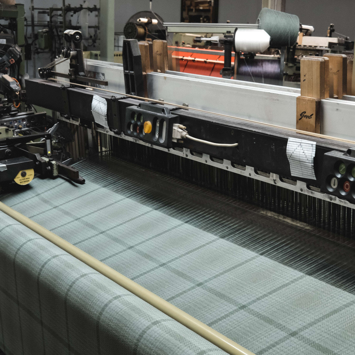 Textile production line with fabric on a loom in a factory setting