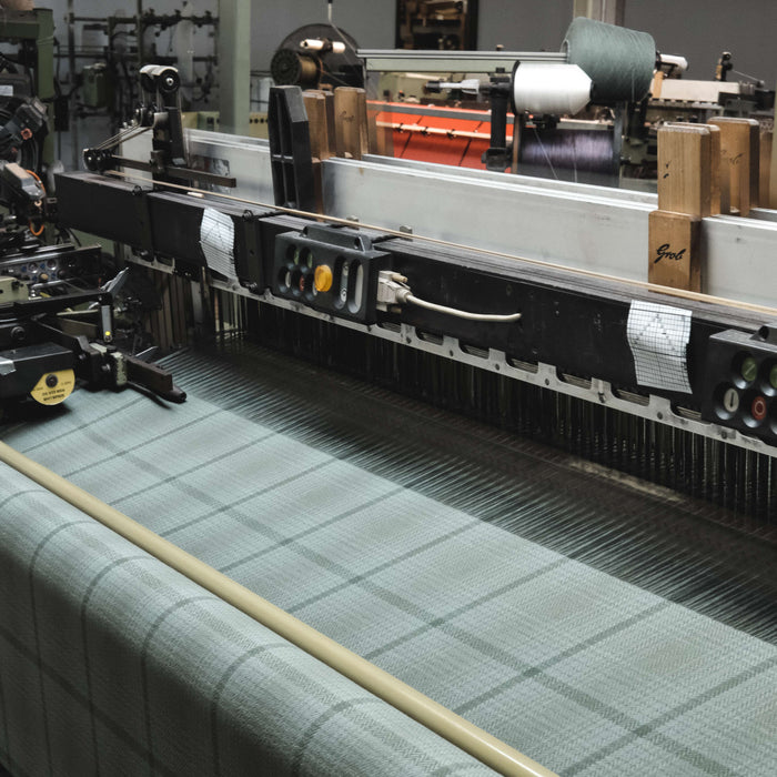 Textile production line with fabric on a loom in a factory setting