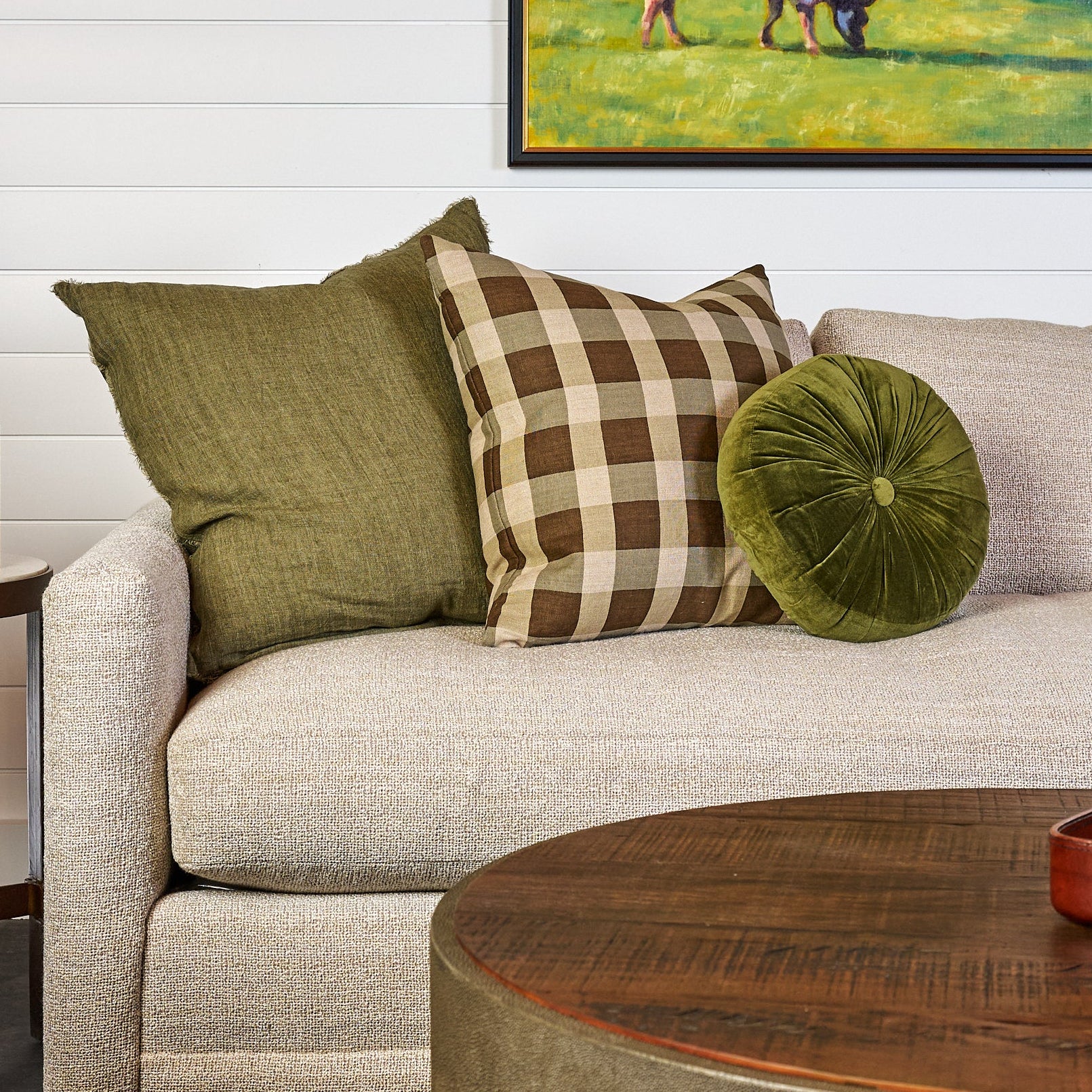 Velvet Tuft Round Cushion in Moss and Lina Linen 24" Square Pillow in Kelp and Ezra Mist Pillow 22" on a sofa at Addison West