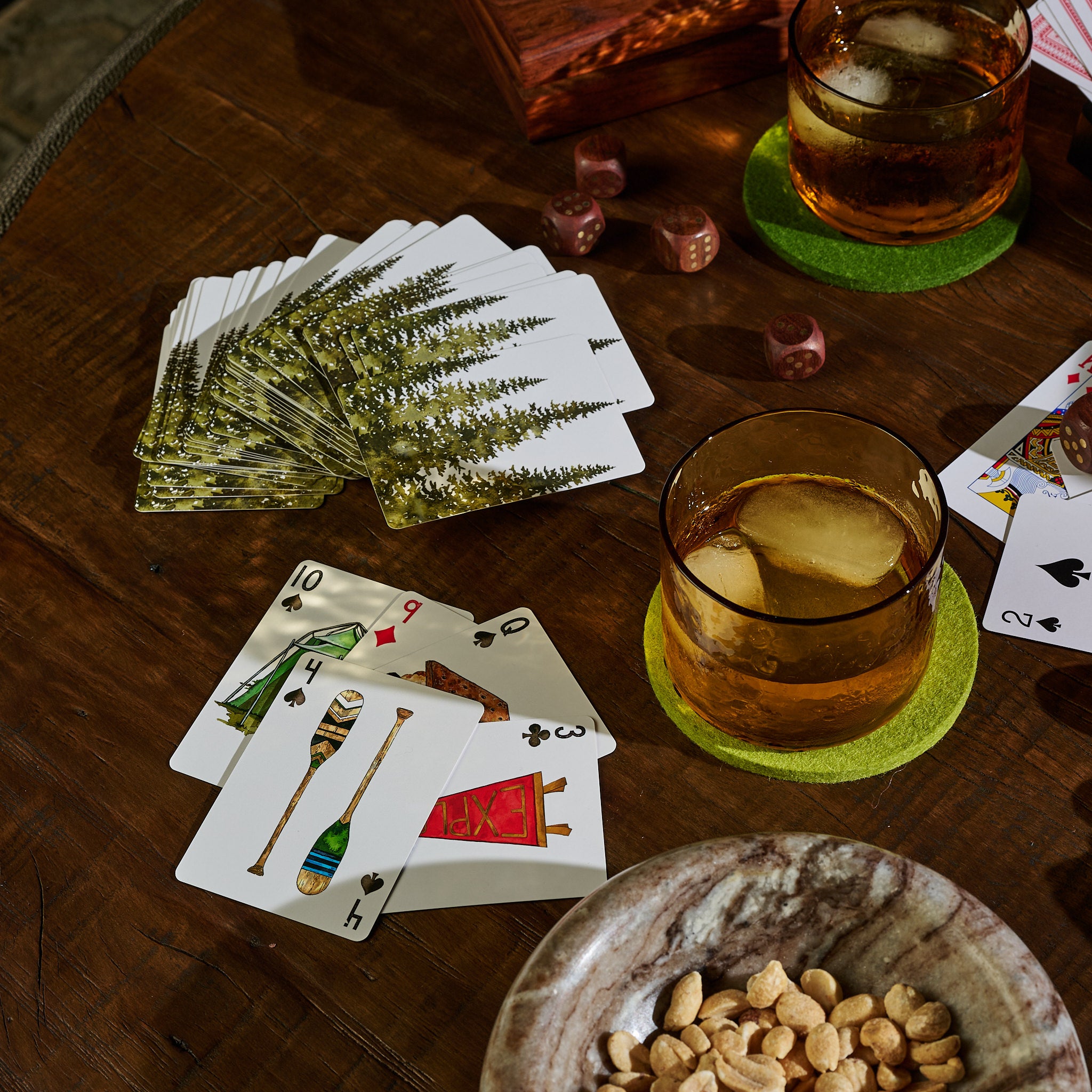 Camping playing cards on a dark wood coffee table at Addison West