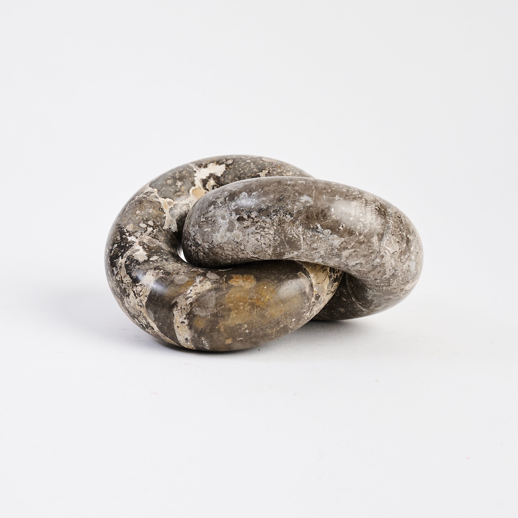 Marble Links Sculpture on white background at Addison West.