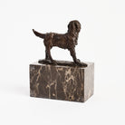 Bronze Dog Statue on Marble Block on a white background at Addison West