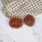 Redecker Copper Pot Scrubber, Set of 2 on a marble table at Addison West
