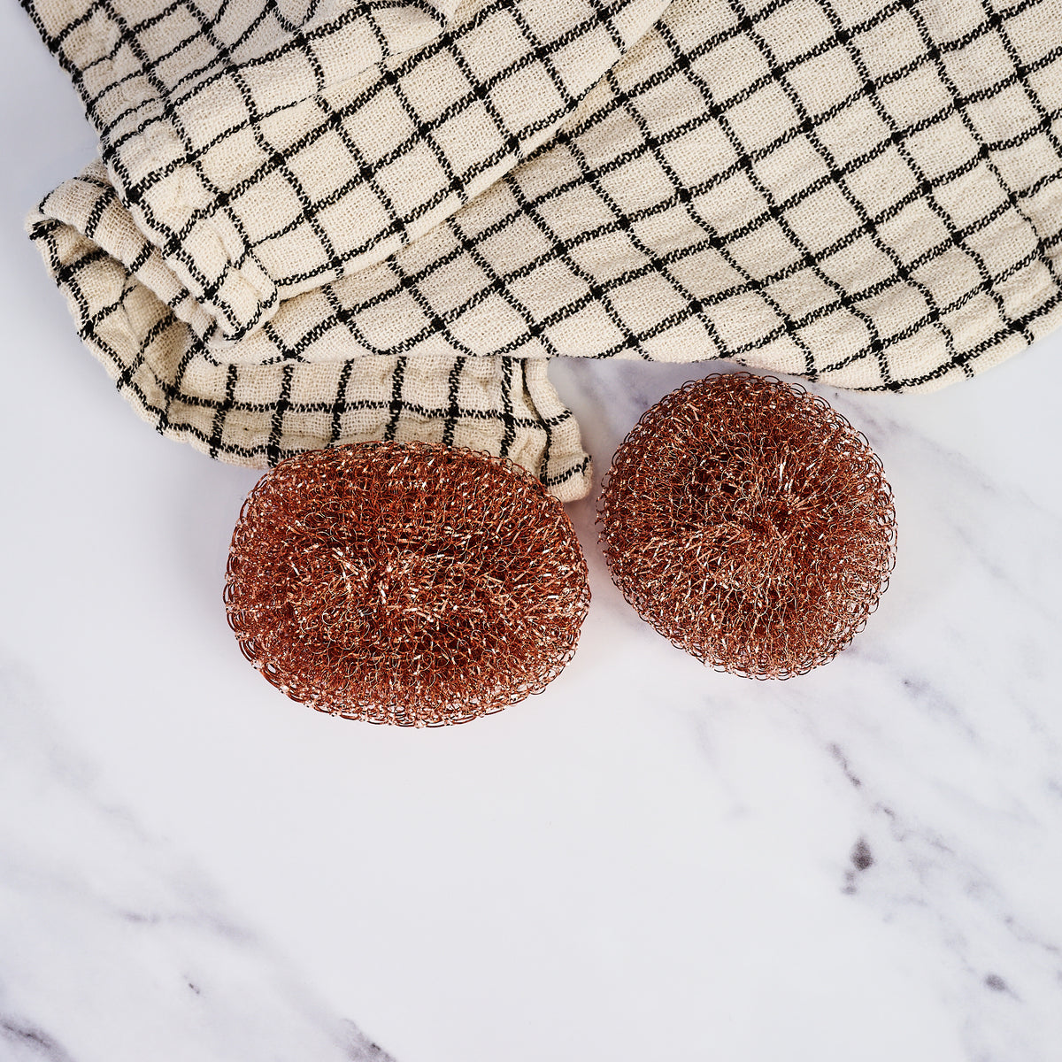 Redecker Copper Pot Scrubber, Set of 2 on a marble table at Addison West