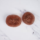 Redecker Copper Pot Scrubber, Set of 2 on a marble table at Addison West