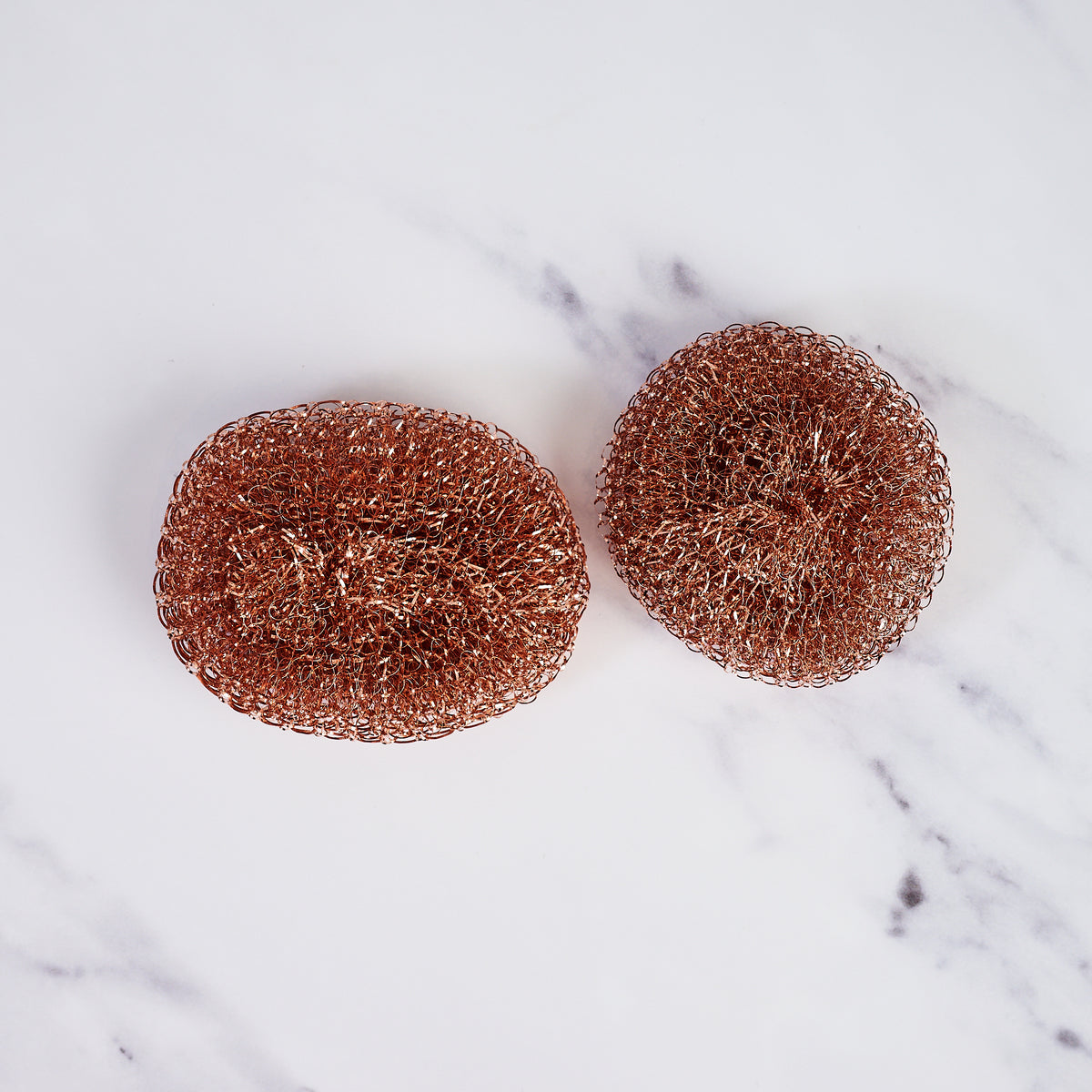 Redecker Copper Pot Scrubber, Set of 2 on a marble table at Addison West