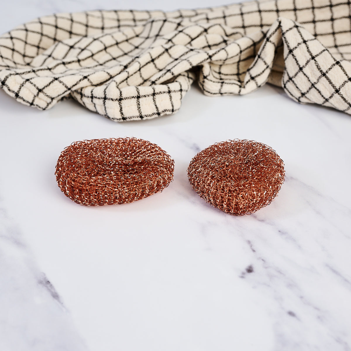Redecker Copper Pot Scrubber, Set of 2 on a marble table at Addison West