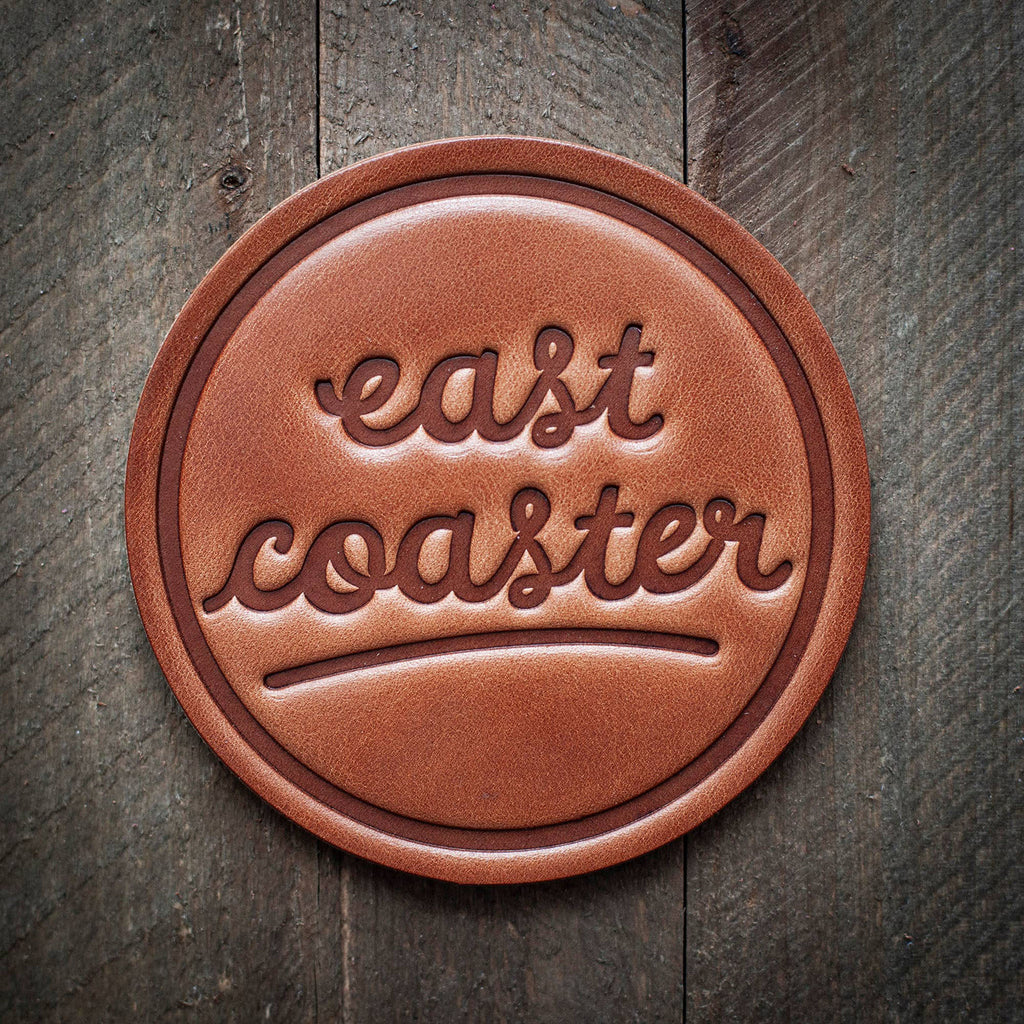 East Coaster Leather Coaster on a wood surface