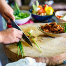Chef chopping vegetables on a cutting board.