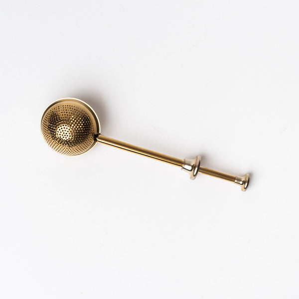 Brass tea infuser on a white background