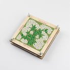 Flower press with image of forget me not flowers painted on the front on a white background