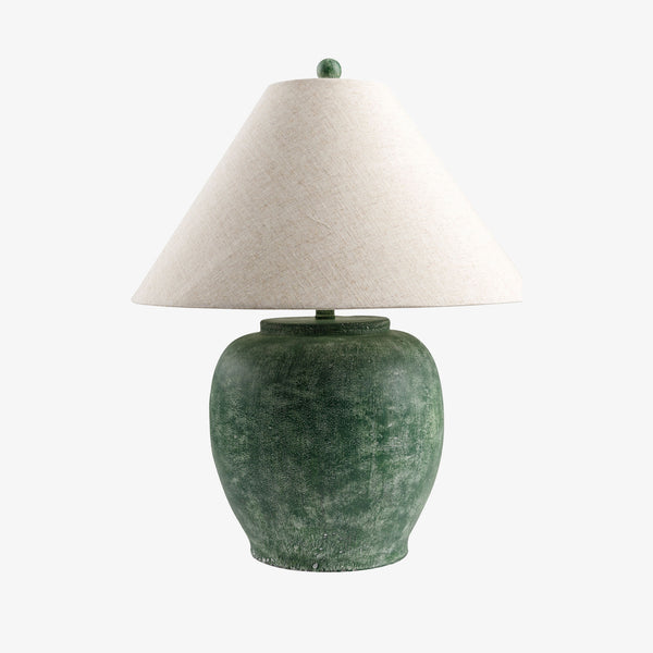 Dark green cement lamp with flared linen shade on a white background
