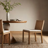 Four Hands Zuma Dining Chair with beige cushion and woven back in Dune Ash in a dining space 