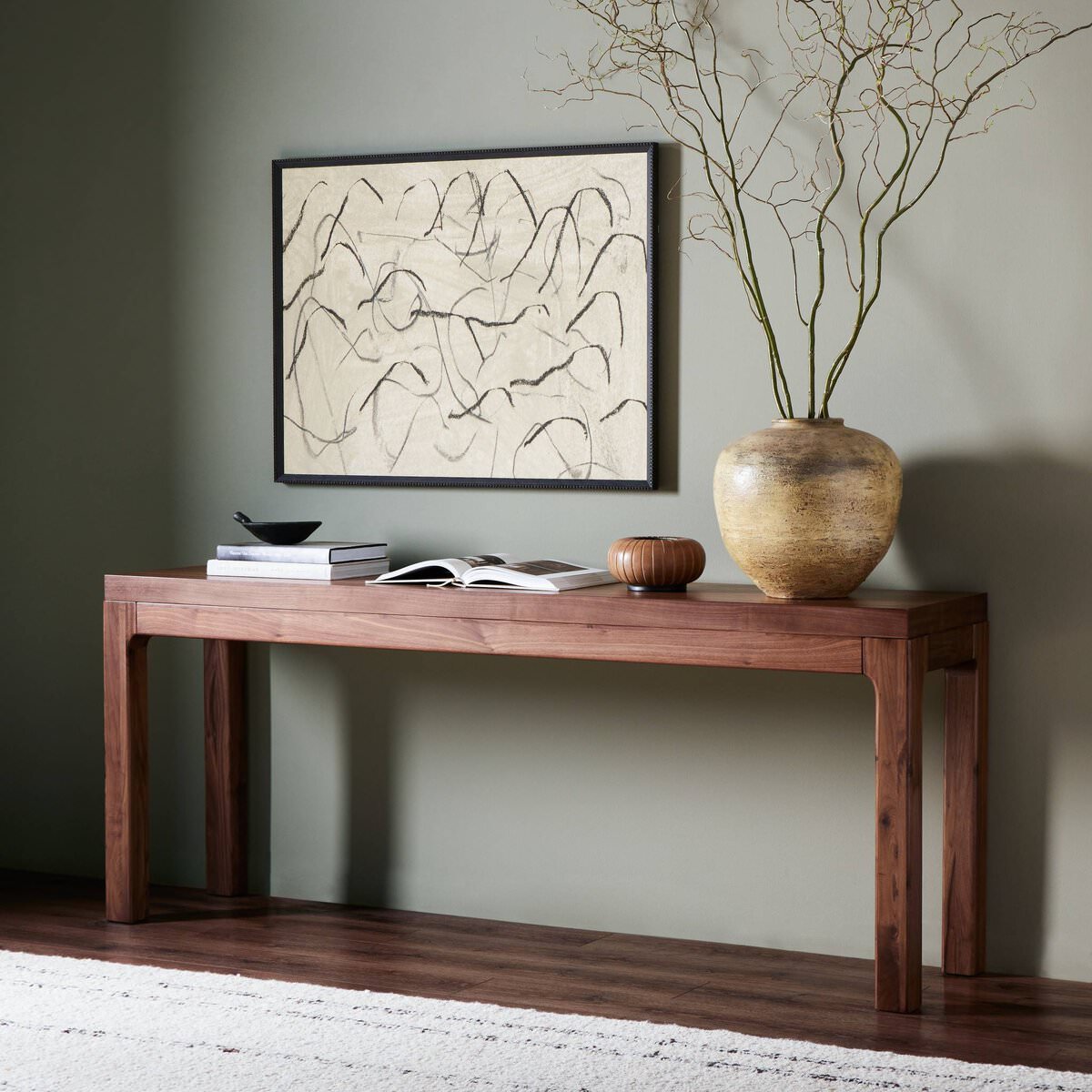 Four Hands Arturo Console Table in Natural Walnut Veneer in a modern home with green walls